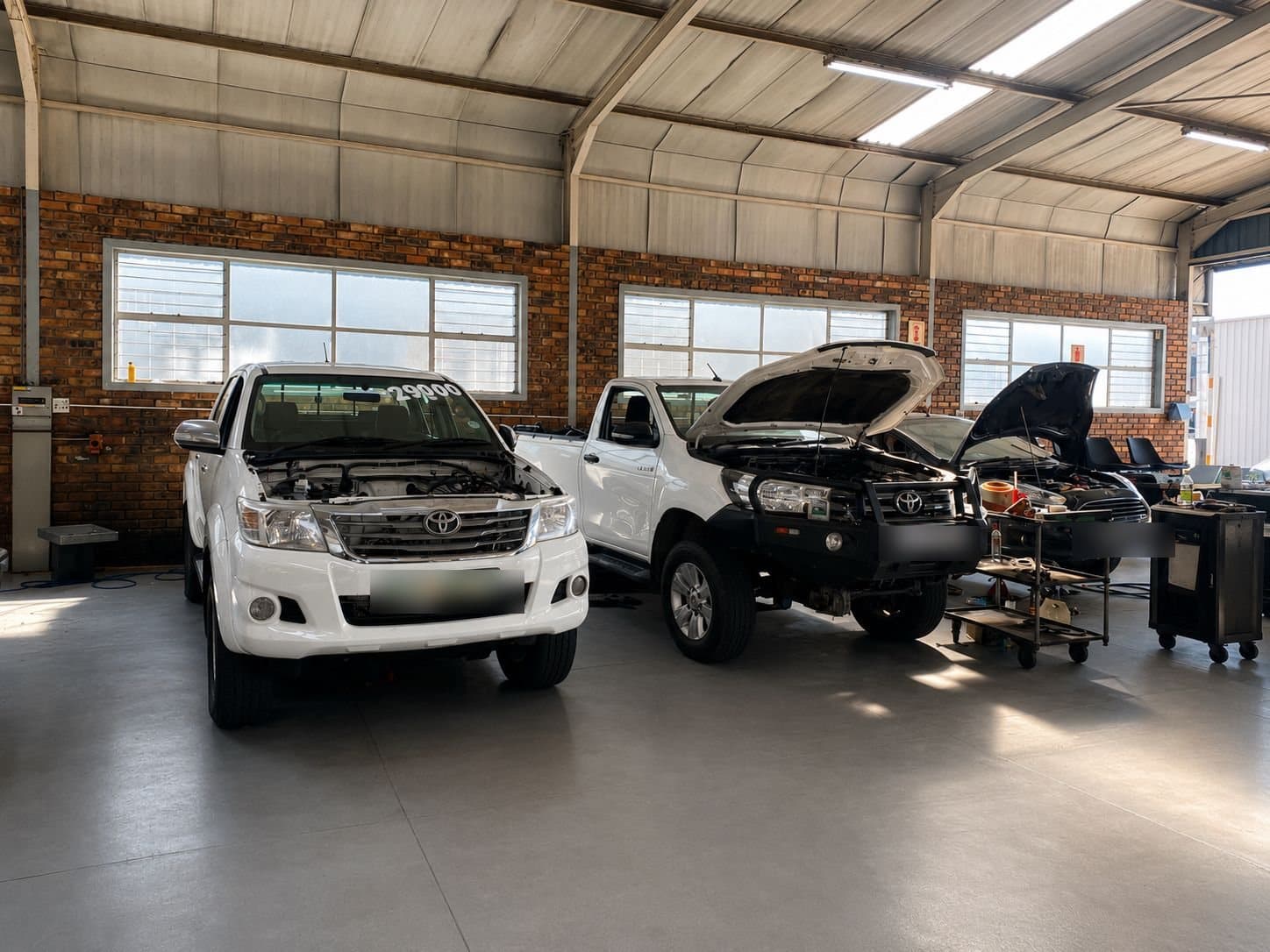 Customer vehicles up on the ramps in the Vision Motors workshop, Wonderboom South, Pretoria